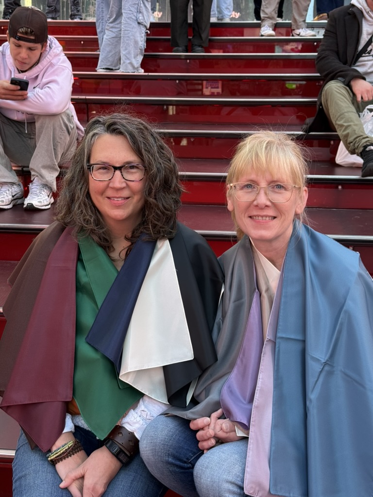 Twee vrouwen met kleurrijke analysedoeken op de rode trappen van Times Square